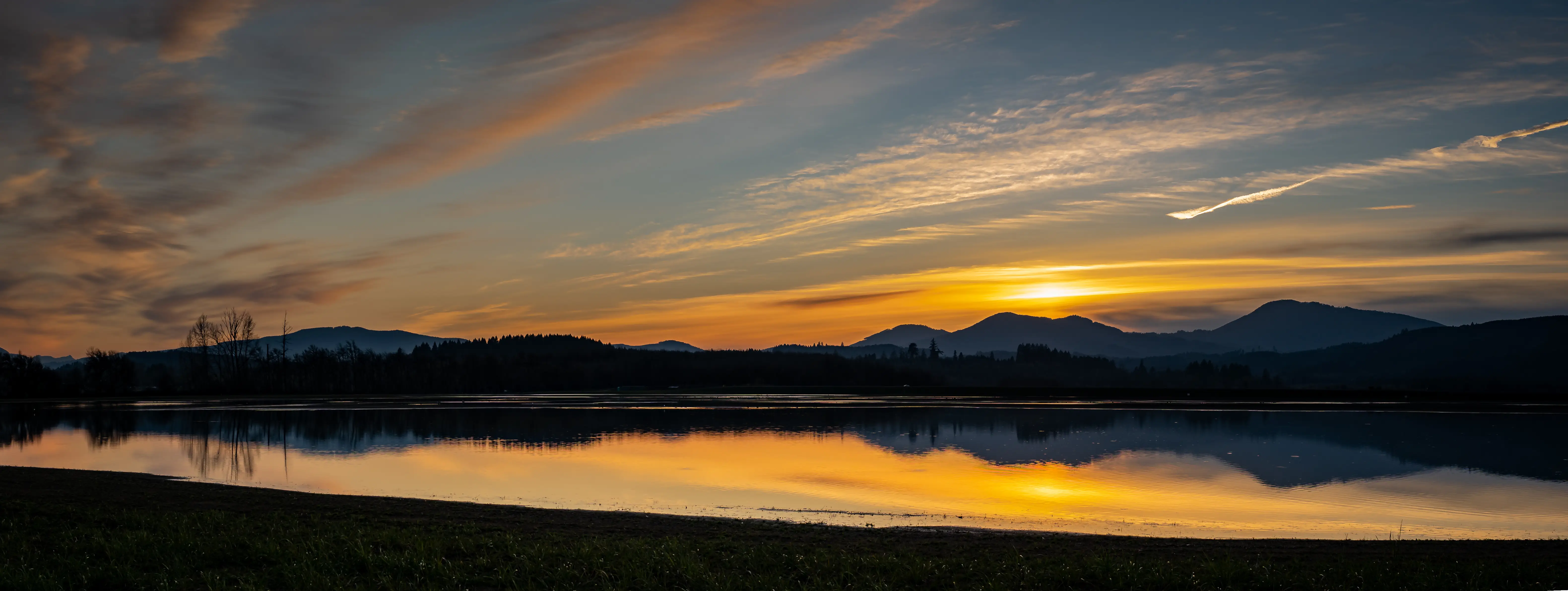 Sunset over a calm lake reflecting the Coast Range mountains near Philomath, Oregon